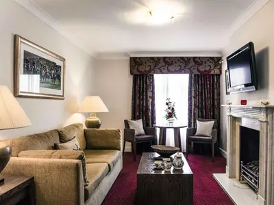 a living room with a couch and a fireplace at Mercure Haydock Hotel in Haydock