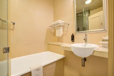 a white bathroom with a sink and a shower at Atlantic Tower Hotel Liverpool By Sunday in Liverpool