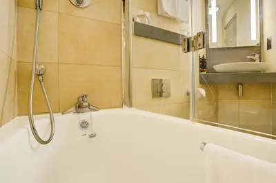 a bathroom with a tub with a shower and a sink at Atlantic Tower Hotel Liverpool By Sunday in Liverpool