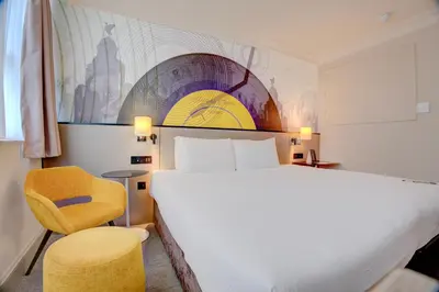 a hotel room with a large bed and a chair at Atlantic Tower Hotel Liverpool By Sunday in Liverpool