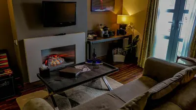 a living room with a couch and a fireplace at The Big Blue Hotel - Blackpool Pleasure Beach in Blackpool