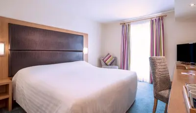 a hotel room with a bed and a desk and a television at The Big Blue Hotel - Blackpool Pleasure Beach in Blackpool