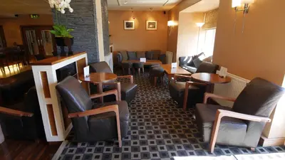 a restaurant with tables and chairs in a room at The Big Blue Hotel - Blackpool Pleasure Beach in Blackpool