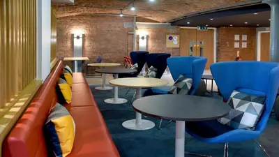 a waiting room with tables and blue chairs at Holiday Inn Express Liverpool-Albert Dock by IHG in Liverpool