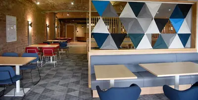 a row of tables and chairs in a restaurant at Holiday Inn Express Liverpool-Albert Dock by IHG in Liverpool