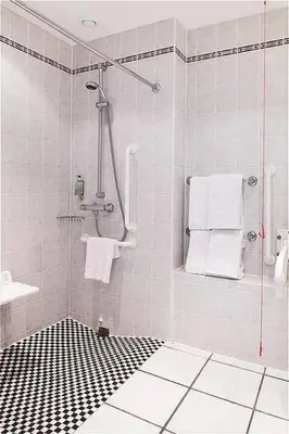 a bathroom with a shower with a black and white floor at Holiday Inn Express Liverpool-Albert Dock by IHG in Liverpool