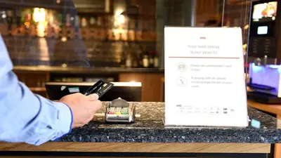 a person holding a cell phone on a counter at Holiday Inn Express Liverpool-Albert Dock by IHG in Liverpool
