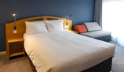 a bedroom with a large white bed and a chair at Holiday Inn Express Liverpool-Albert Dock by IHG in Liverpool