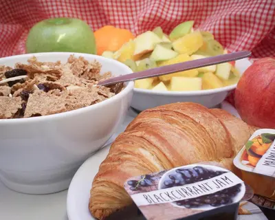 a table with bowls of food and a plate of bread and fruit at The Dolby Hotel Liverpool - Free city centre parking in Liverpool