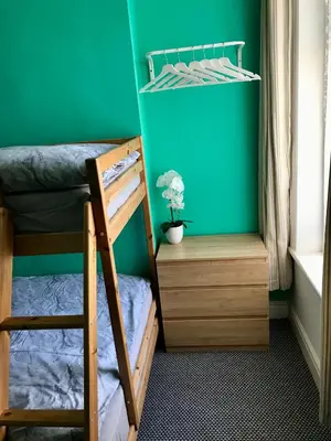 a bedroom with two bunk beds and a green wall at Yado Hotel in Blackpool
