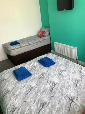 two beds in a room with blue pillows on them at Yado Hotel in Blackpool