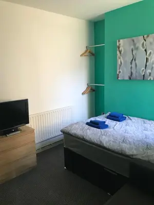 a room with a bed and a flat screen tv at Yado Hotel in Blackpool