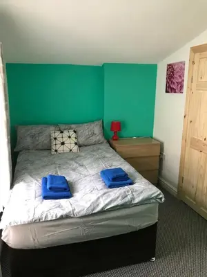 a bedroom with a bed with blue towels on it at Yado Hotel in Blackpool
