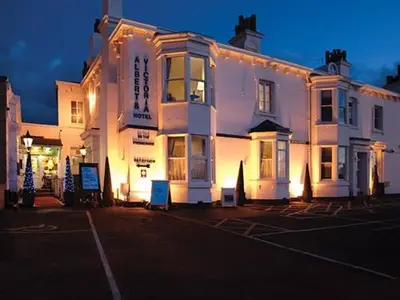 a large white building with lights on a street at Albert & Victoria Hotel in Southport