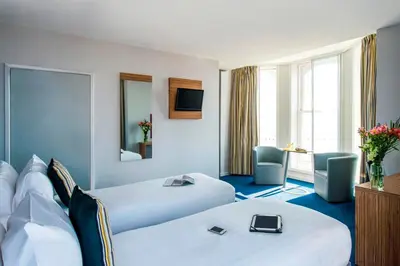 a hotel room with two beds and a television at Forshaws Hotel - Blackpool in Blackpool