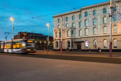 a bus driving down a street in front of a building at Forshaws Hotel - Blackpool in Blackpool