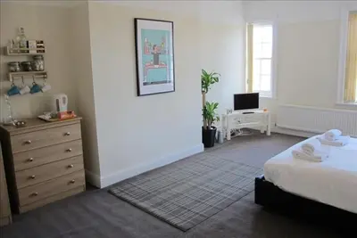 a bedroom with a bed and a dresser and a television at The Jollys in Bootle