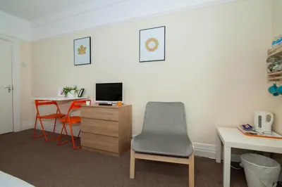 a room with a desk and a chair and a table at The Jollys in Bootle