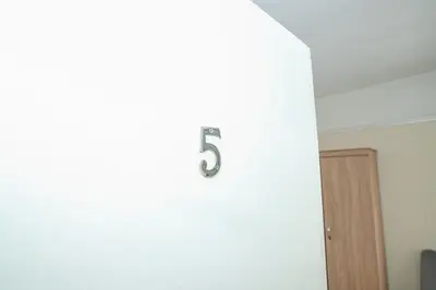 a number on a white wall in a room at The Jollys in Bootle