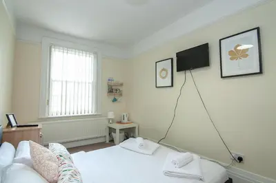 a bedroom with a bed and a television on the wall at The Jollys in Bootle