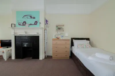 a bedroom with a bed and a fireplace and a dresser at The Jollys in Bootle