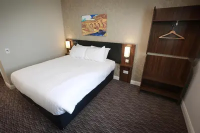 a hotel room with a large bed with white sheets at Willows, Blackburn by Marston's Inn in Blackburn