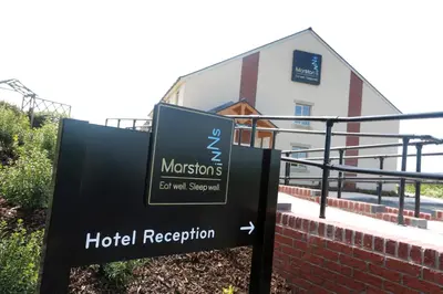 a sign for a hotel reception in front of a building at Willows, Blackburn by Marston's Inn in Blackburn