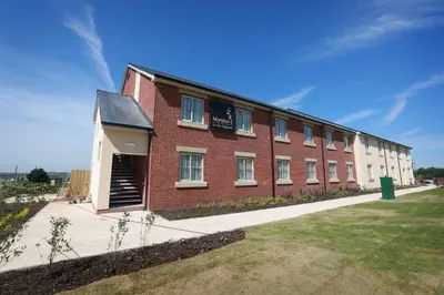 a large red brick building with a garage at Willows, Blackburn by Marston's Inn in Blackburn