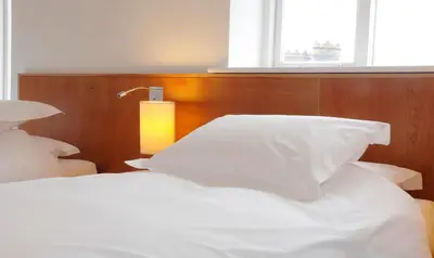 a bed with white sheets and a light on it at Hope Street Hotel in Liverpool