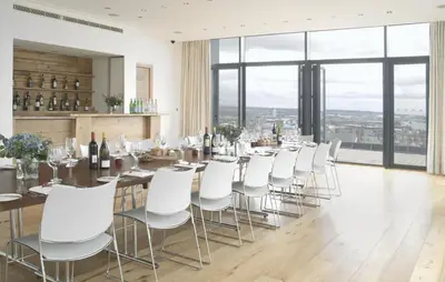 a dining room with a long table and white chairs at Hope Street Hotel in Liverpool
