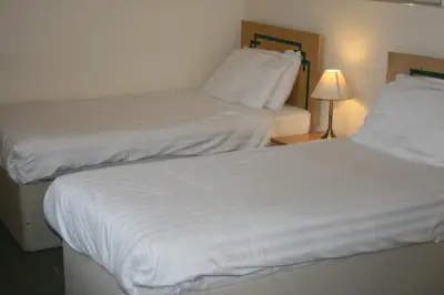 two beds in a hotel room next to a lamp at Hanover Hotel & McCartney's Bar in Liverpool