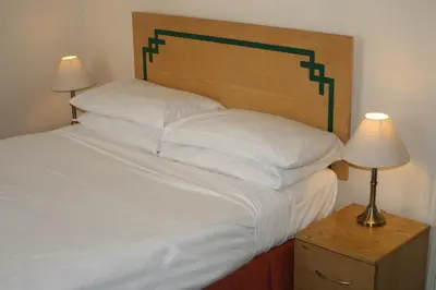 a bedroom with a large bed with white sheets and pillows at Hanover Hotel & McCartney's Bar in Liverpool
