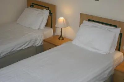 a bedroom with two beds and a lamp on a night stand at Hanover Hotel & McCartney's Bar in Liverpool