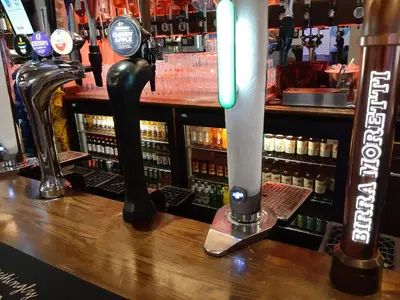 a bar with a row of bottles of beer at Hanover Hotel & McCartney's Bar in Liverpool