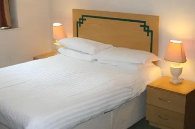 a bedroom with a large white bed with two lamps at Hanover Hotel & McCartney's Bar in Liverpool