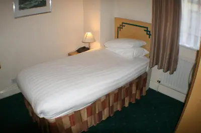 a bedroom with a large bed with white sheets and pillows at Hanover Hotel & McCartney's Bar in Liverpool