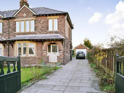 a brick house with a car parked in the driveway at Marstan House in Standish