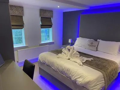 a bedroom with a bed with a stuffed animal on it at The Avenue Hotel Ltd in Clitheroe