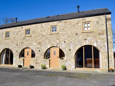 a stone building with four doors and windows at Holgate's Granary in Pendleton