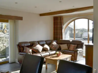 a living room with a leather couch and a table at Holgate's Granary in Pendleton