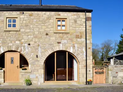 a stone house with a large door and windows at Holgate's Granary in Pendleton
