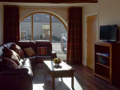 a living room with a couch and a tv at Holgate's Granary in Pendleton