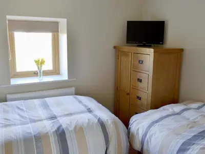 a bedroom with a bed and a television on a dresser at Holgate's Granary in Pendleton