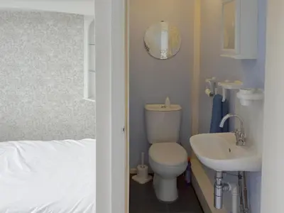 a small bathroom with a toilet and a sink at Rossall Beach Cottage in Cleveleys