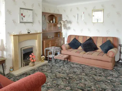 a living room with a couch and a fireplace at Rossall Beach Cottage in Cleveleys