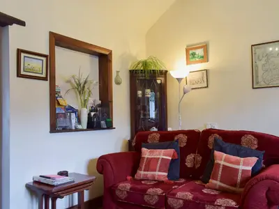 a living room with a red couch and a mirror at The Dairy in Burscough