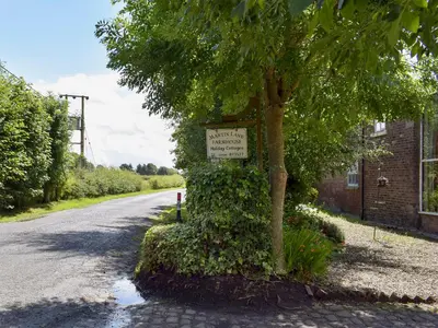 a sign on a tree on the side of a road at The Dairy in Burscough
