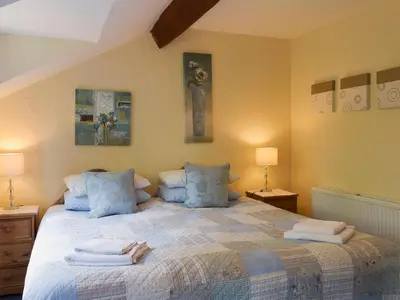 a bedroom with a large bed with towels on it at The Shippon in Burscough