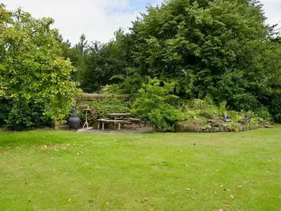 a picnic table in a yard with trees and grass at The Granary in Burscough