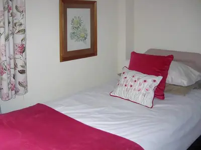 a bed with two red and white pillows on it at The Granary in Burscough
